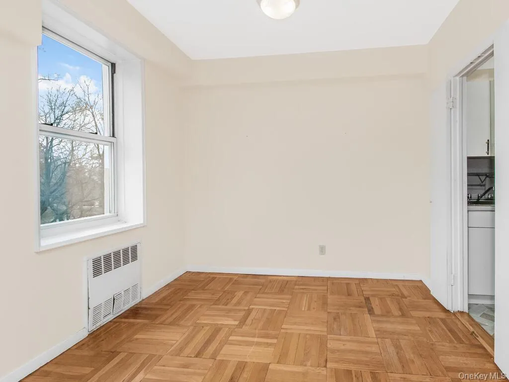 Empty room featuring radiator heating unit and baseboards Empty room featuring radiator heating unit and baseboards