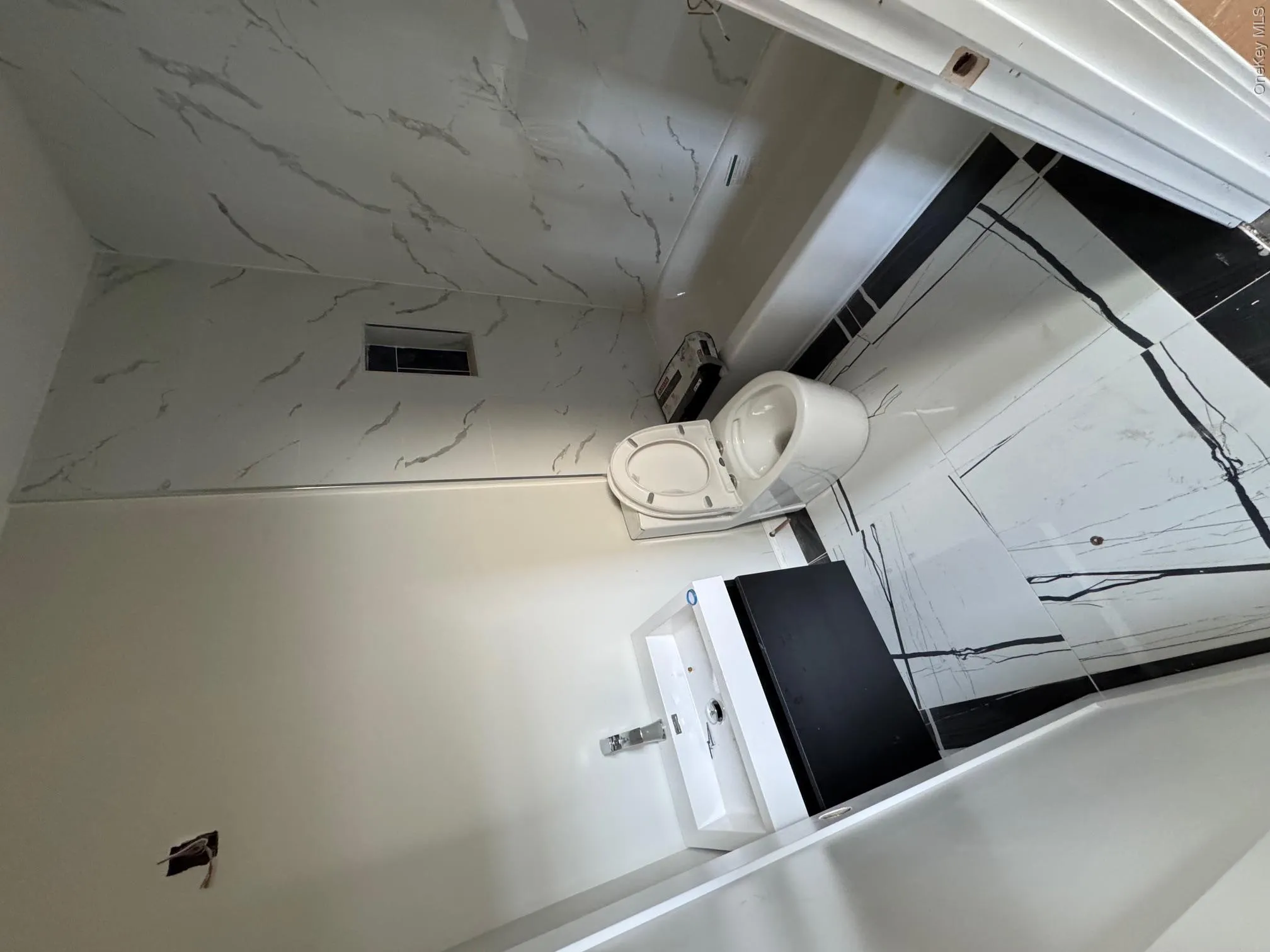 Bathroom featuring marble finish floor, vanity, and toilet Bathroom featuring marble finish floor, vanity, and toilet