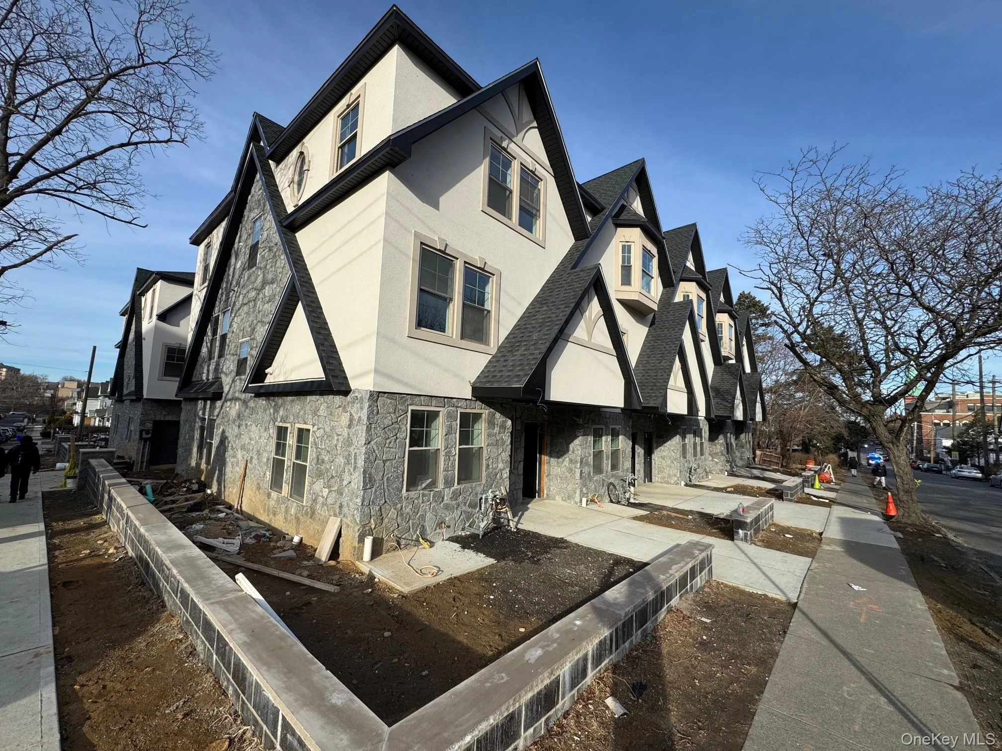 View of home's exterior with stone siding, roof with shingles, a residential view, and stucco siding View of home's exterior with stone siding, roof with shingles, a residential view, and stucco siding