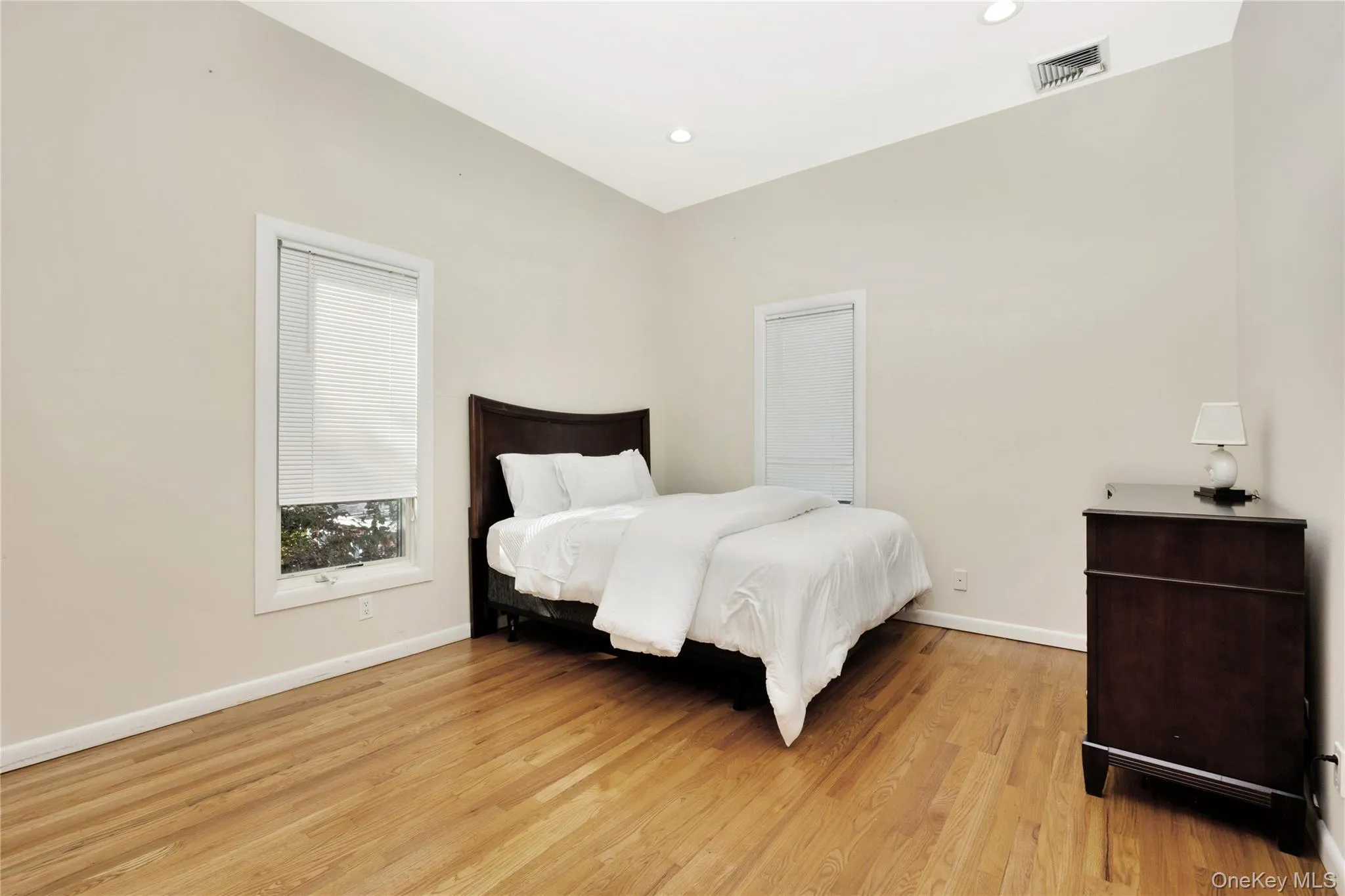 Bedroom featuring recessed lighting, visible vents, light wood-style flooring, and baseboards Bedroom featuring recessed lighting, visible vents, light wood-style flooring, and baseboards