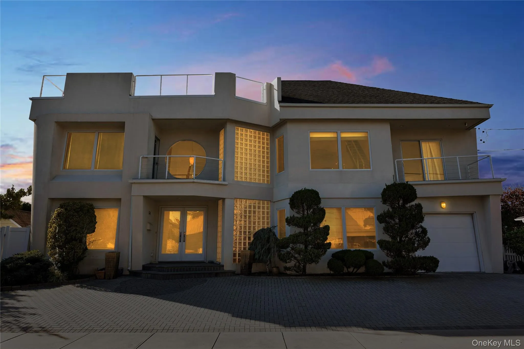 View of front of home with a garage, a balcony, and stucco siding View of front of home with a garage, a balcony, and stucco siding