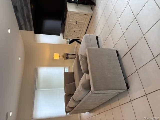 Living room with light tile patterned floors and recessed lighting Living room with light tile patterned floors and recessed lighting