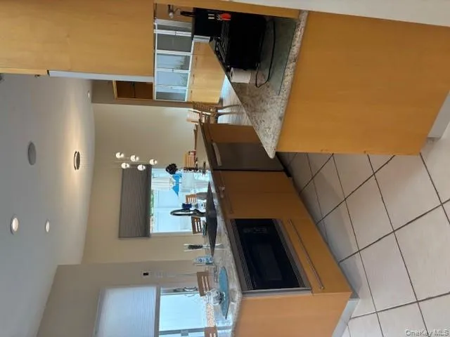 Kitchen with pendant lighting, light tile patterned floors, a kitchen island with sink, light stone countertops, and recessed lighting Kitchen with pendant lighting, light tile patterned floors, a kitchen island with sink, light stone countertops, and recessed lighting