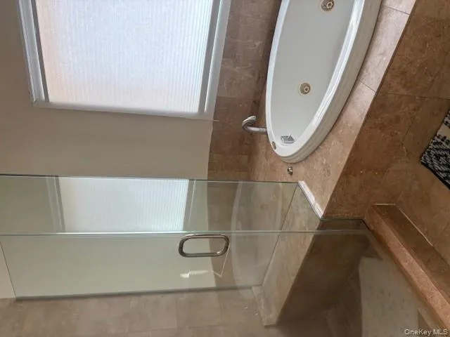 Full bathroom with a tub with jets and a stall shower Full bathroom with a tub with jets and a stall shower