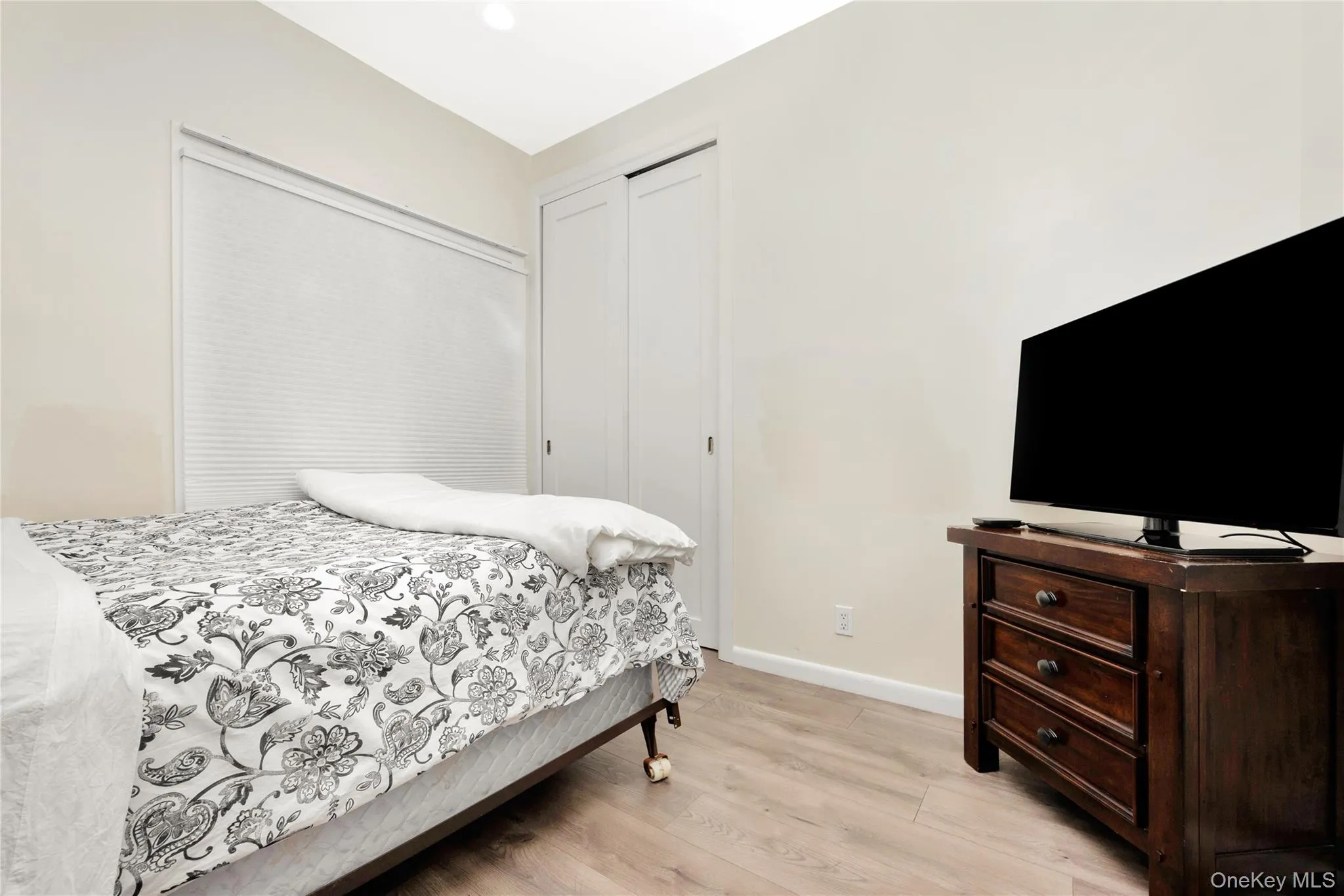 Bedroom with light wood finished floors, a closet, and baseboards Bedroom with light wood finished floors, a closet, and baseboards