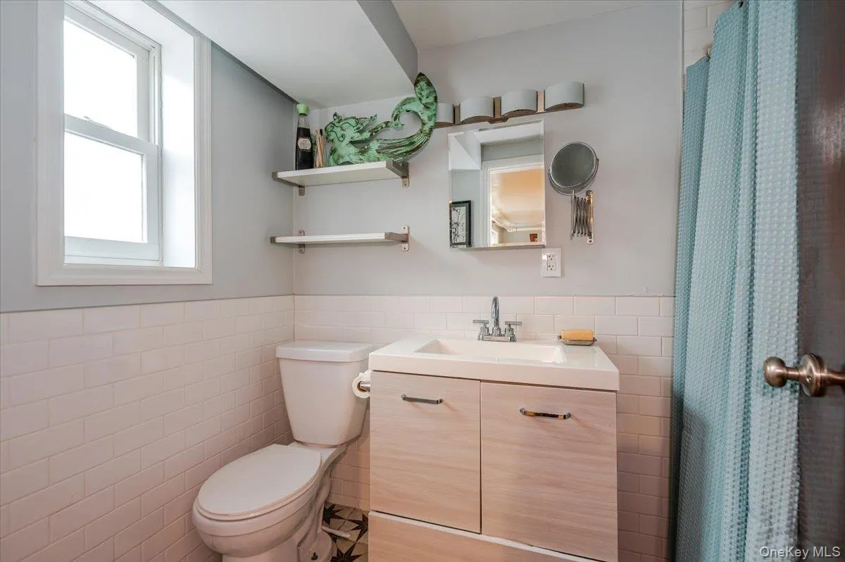 Full Bathroom featuring wainscoting tile walls, and vanity Full Bathroom featuring wainscoting tile walls, and vanity