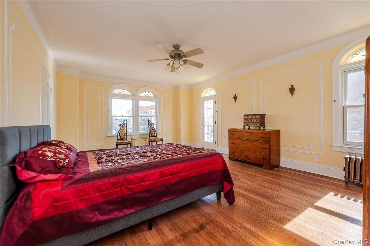 King sized, Sun-filled Primary Bedroom featuring ornamental molding, wood floors, ensuite bathroom, and private oceanview terrace King sized, Sun-filled Primary Bedroom featuring ornamental molding, wood floors, ensuite bathroom, and private oceanview terrace