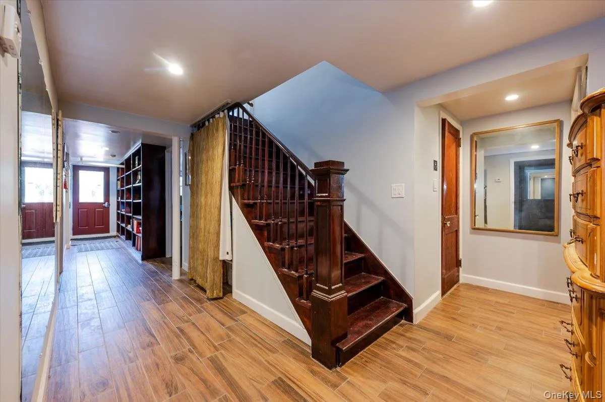 Stairway to Lower/Garden Level featuring Outside Entrance, recessed lighting, baseboards, and wood finished floors. Stairway to Lower/Garden Level featuring Outside Entrance, recessed lighting, baseboards, and wood finished floors.