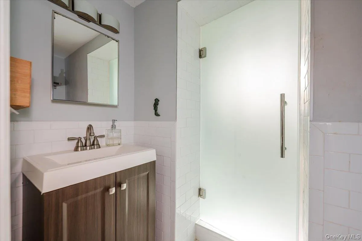 Bathroom with wainscoting, tile walls, and vanity Bathroom with wainscoting, tile walls, and vanity