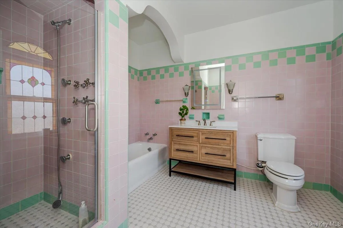 Updated Ensuite Primary Full bath featuring a separate tub and stall shower, and tile walls Updated Ensuite Primary Full bath featuring a separate tub and stall shower, and tile walls
