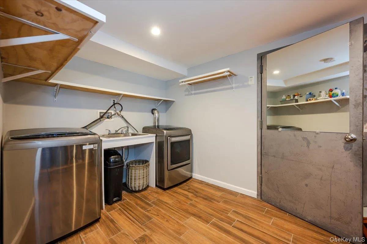 Laundry room featuring a sink, washer and dryer, and access to utility room. Laundry room featuring a sink, washer and dryer, and access to utility room.