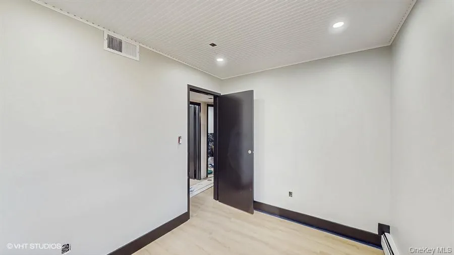 Unfurnished room with light wood-type flooring, recessed lighting, baseboards, and visible vents Unfurnished room with light wood-type flooring, recessed lighting, baseboards, and visible vents