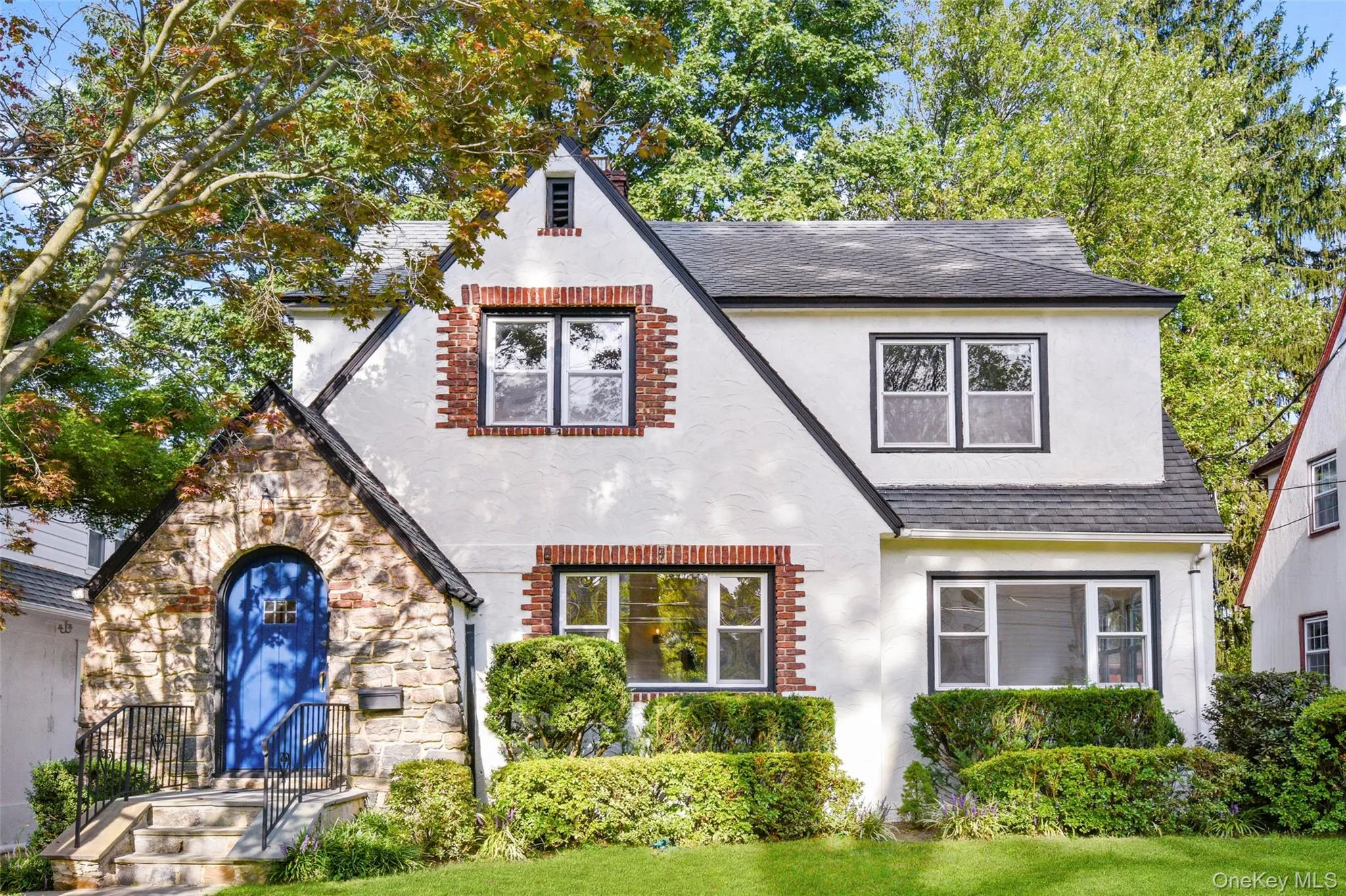 Tudor-style house with a shingled roof and stucco siding Tudor-style house with a shingled roof and stucco siding