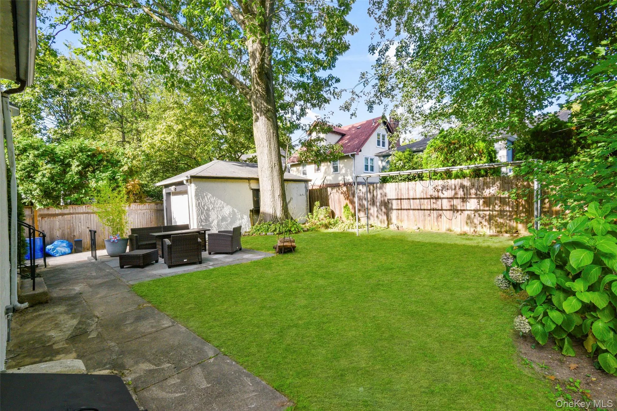 Fenced backyard with a patio, an outdoor structure, and an outdoor hangout area Fenced backyard with a patio, an outdoor structure, and an outdoor hangout area