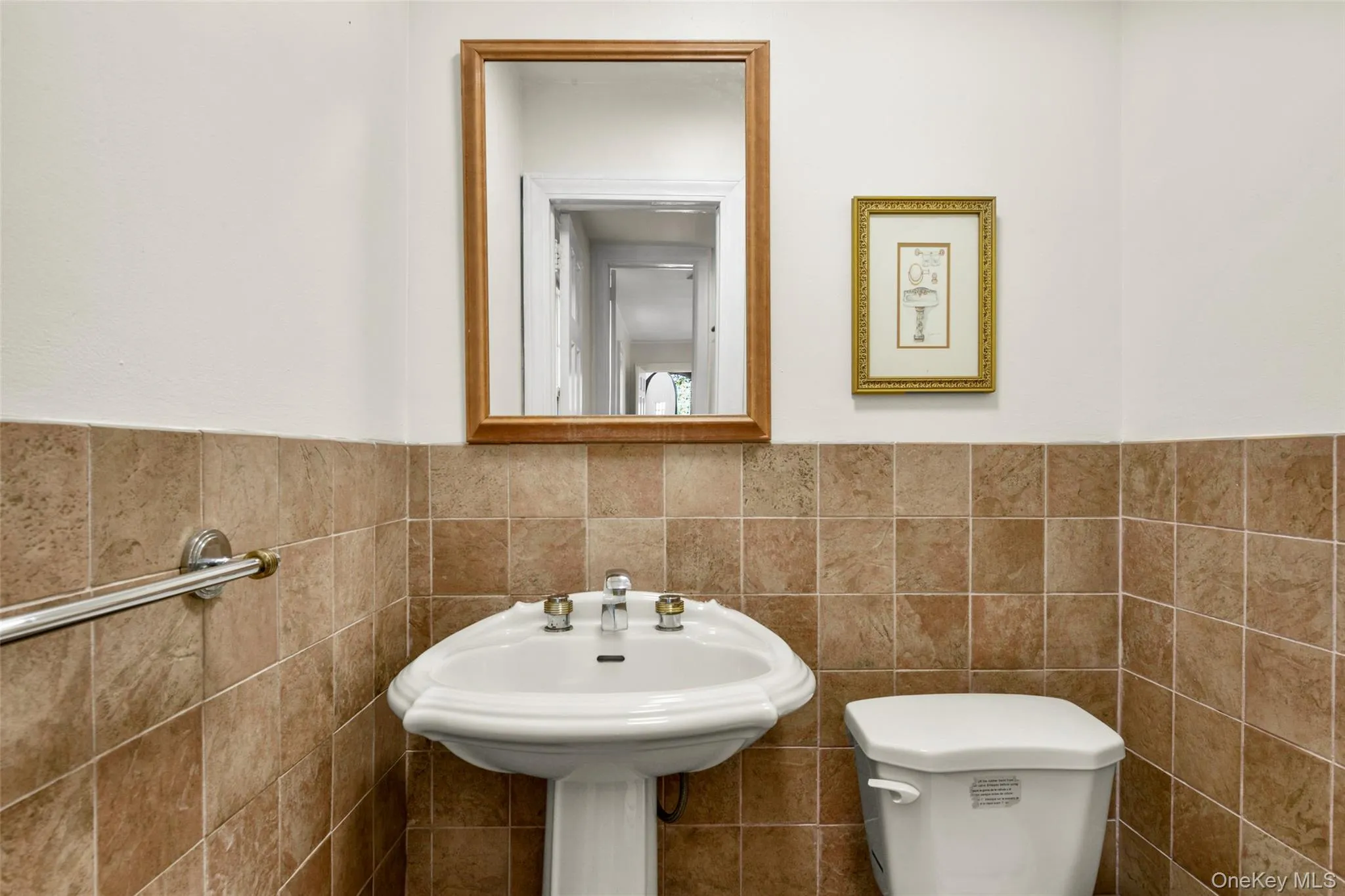 Bathroom featuring tile walls and wainscoting Bathroom featuring tile walls and wainscoting