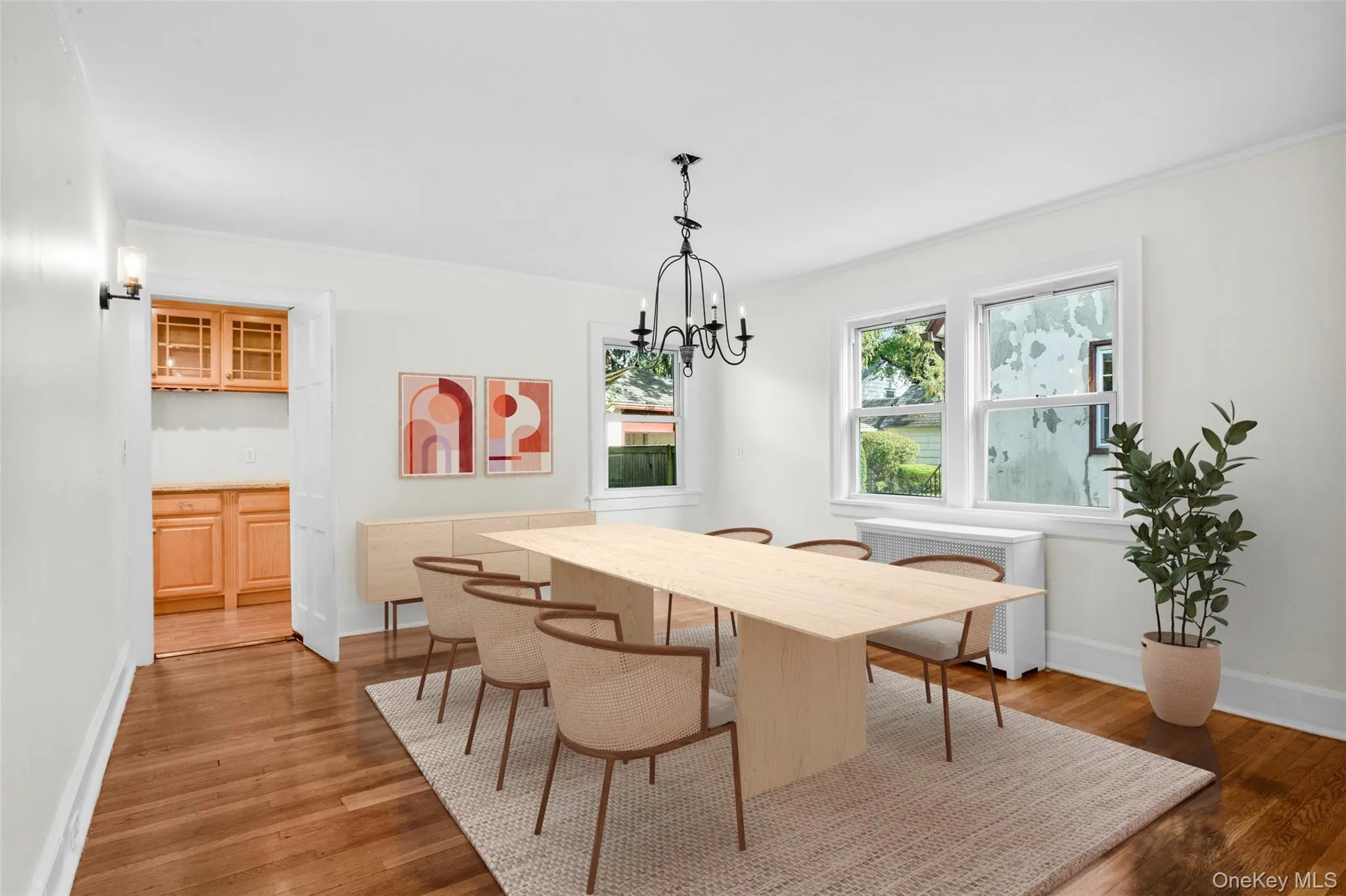 Dining space featuring radiator heating unit, dark wood-type flooring, a chandelier, and crown molding Dining space featuring radiator heating unit, dark wood-type flooring, a chandelier, and crown molding