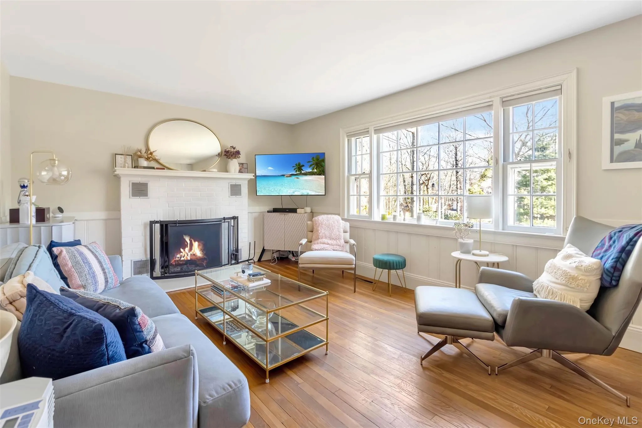Living room featuring hardwood / wood-style flooring, a fireplace, and wainscoting Living room featuring hardwood / wood-style flooring, a fireplace, and wainscoting