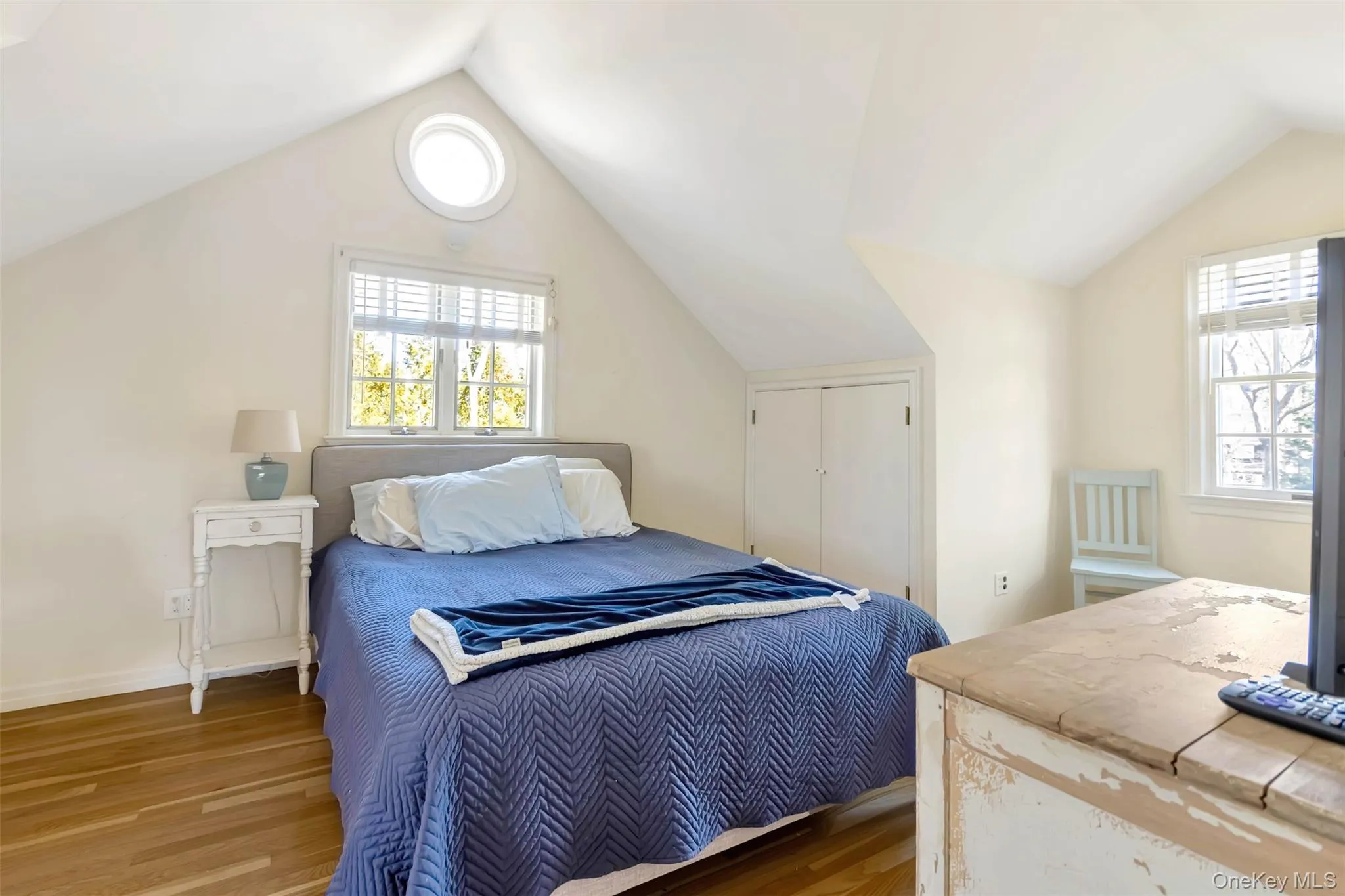 Bedroom featuring lofted ceiling, wood finished floors, and baseboards Bedroom featuring lofted ceiling, wood finished floors, and baseboards