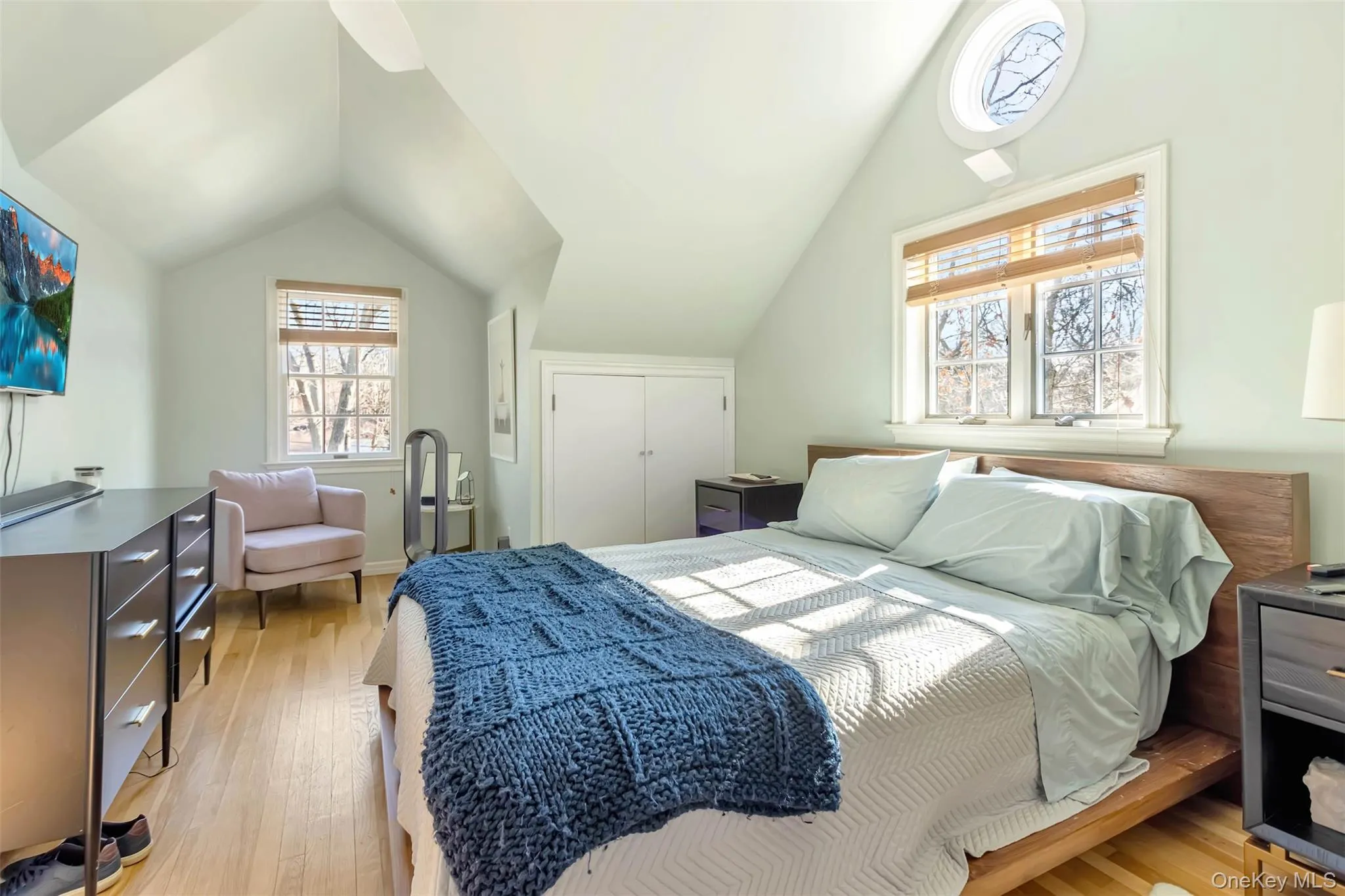 Bedroom featuring lofted ceiling, a closet, and light wood-style flooring Bedroom featuring lofted ceiling, a closet, and light wood-style flooring