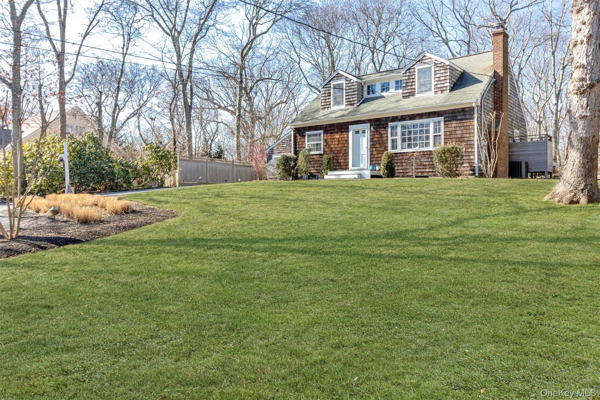 View of front of house featuring roof with shingles, a chimney, a front yard, and fence View of front of house featuring roof with shingles, a chimney, a front yard, and fence