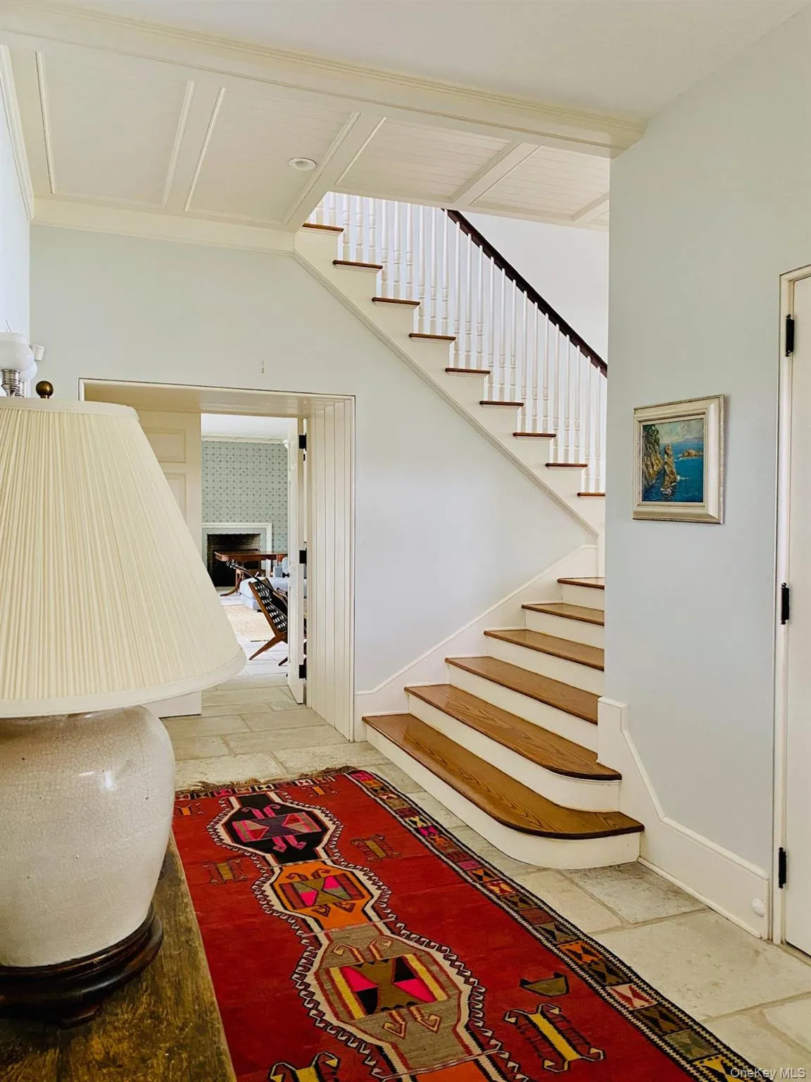 Staircase with a fireplace, stone tile floors, and baseboards Staircase with a fireplace, stone tile floors, and baseboards