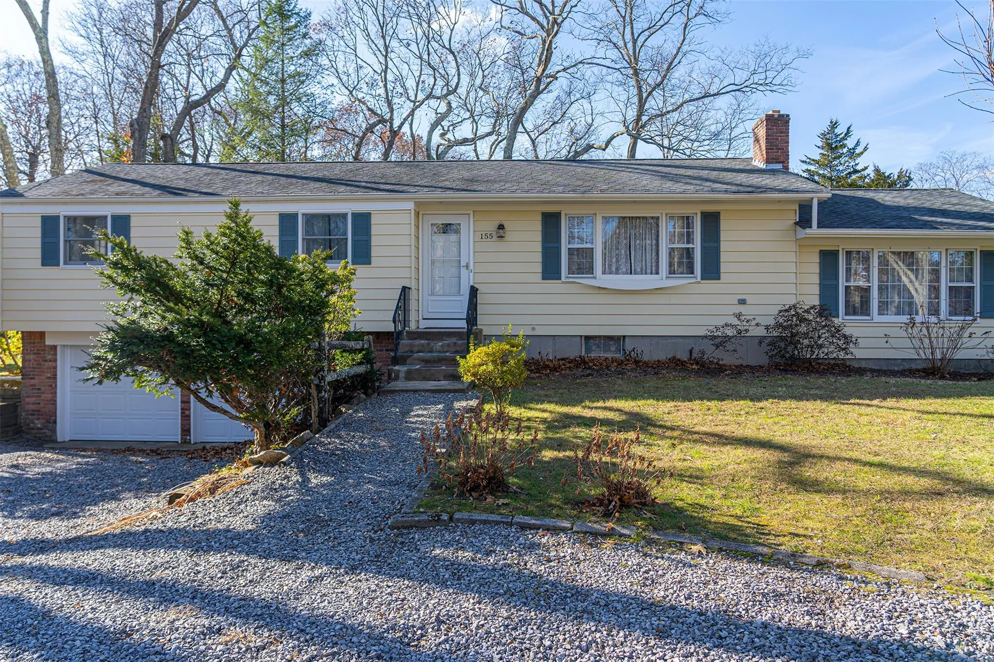 View of front of home with entry steps, an attached garage, driveway, a chimney, and a front yard View of front of home with entry steps, an attached garage, driveway, a chimney, and a front yard