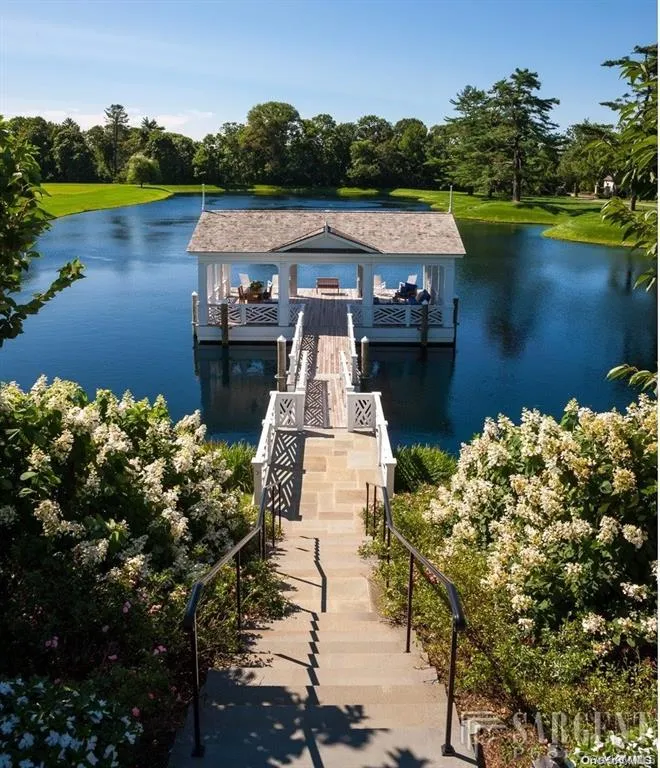 Dock featuring a water view and view of wooded area Dock featuring a water view and view of wooded area