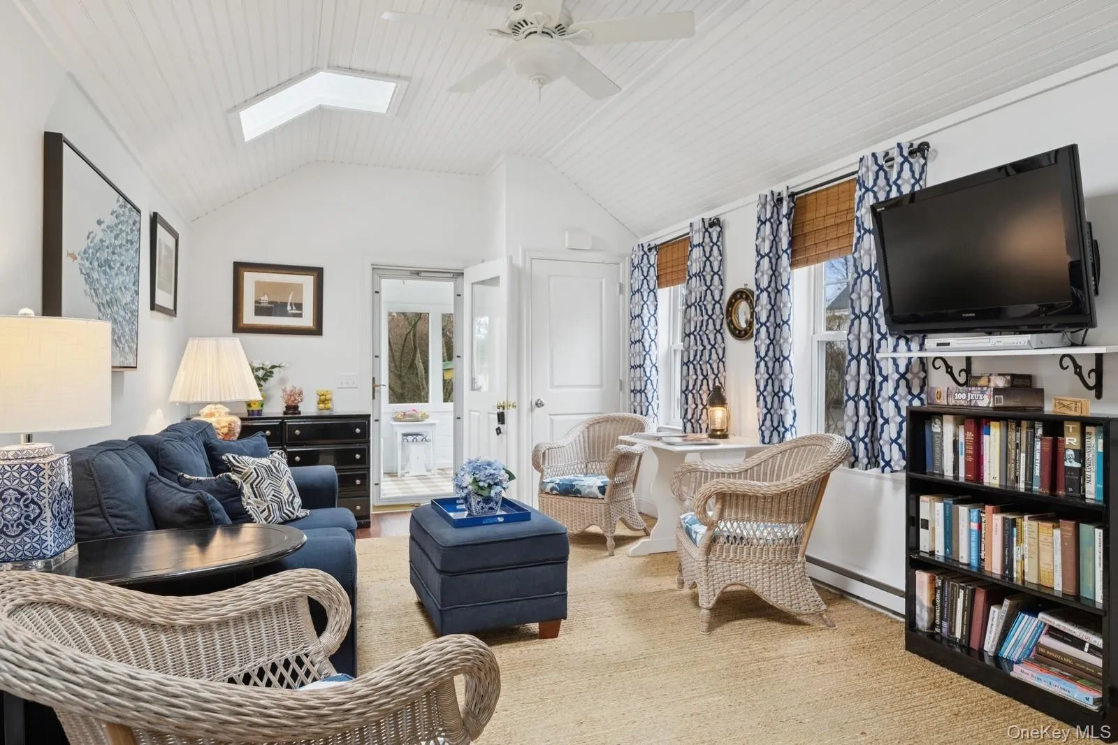 Living room featuring a ceiling fan, vaulted ceiling with skylight, and carpet Living room featuring a ceiling fan, vaulted ceiling with skylight, and carpet