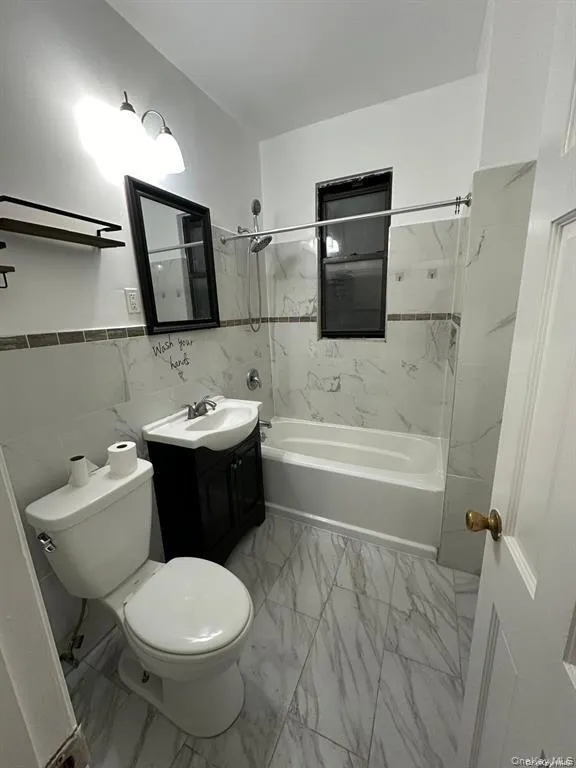 Bathroom featuring marble finish floor, shower / tub combination, vanity, and toilet Bathroom featuring marble finish floor, shower / tub combination, vanity, and toilet