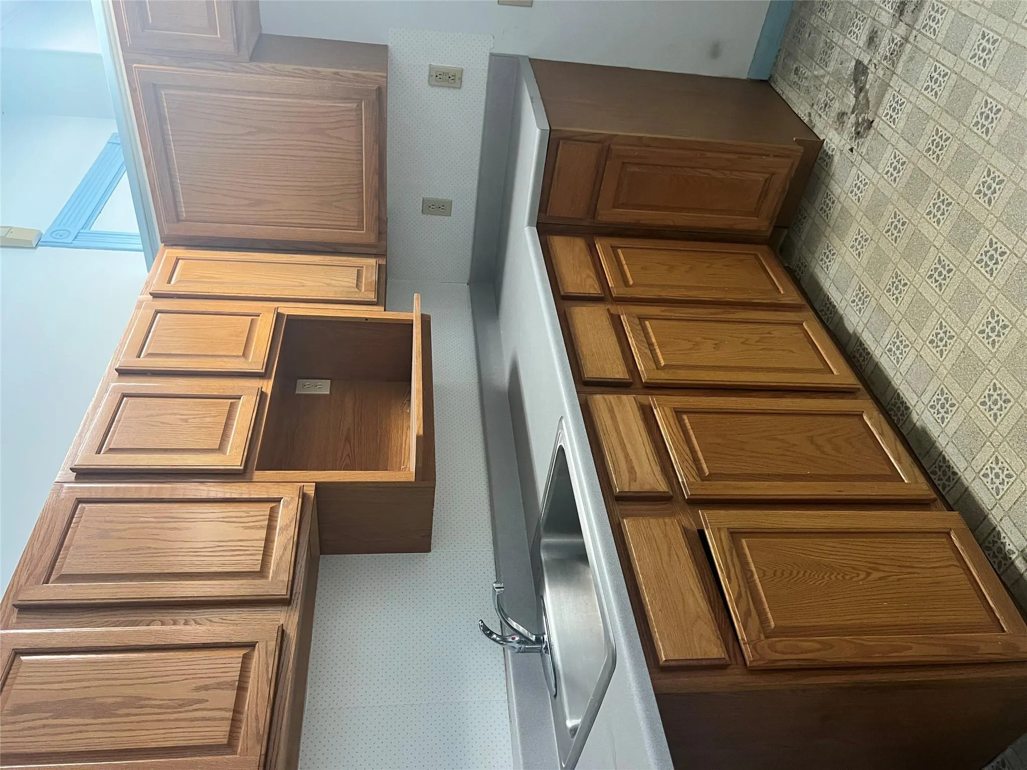 Kitchen featuring brown cabinets, light countertops, and a sink Kitchen featuring brown cabinets, light countertops, and a sink