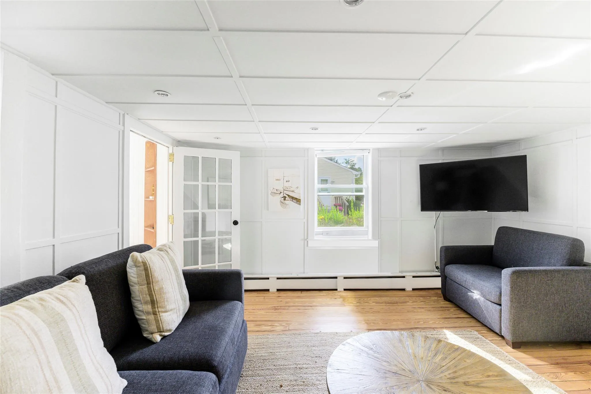 Living area baseboard heating, a decorative wall, and wood finished floors Living area baseboard heating, a decorative wall, and wood finished floors