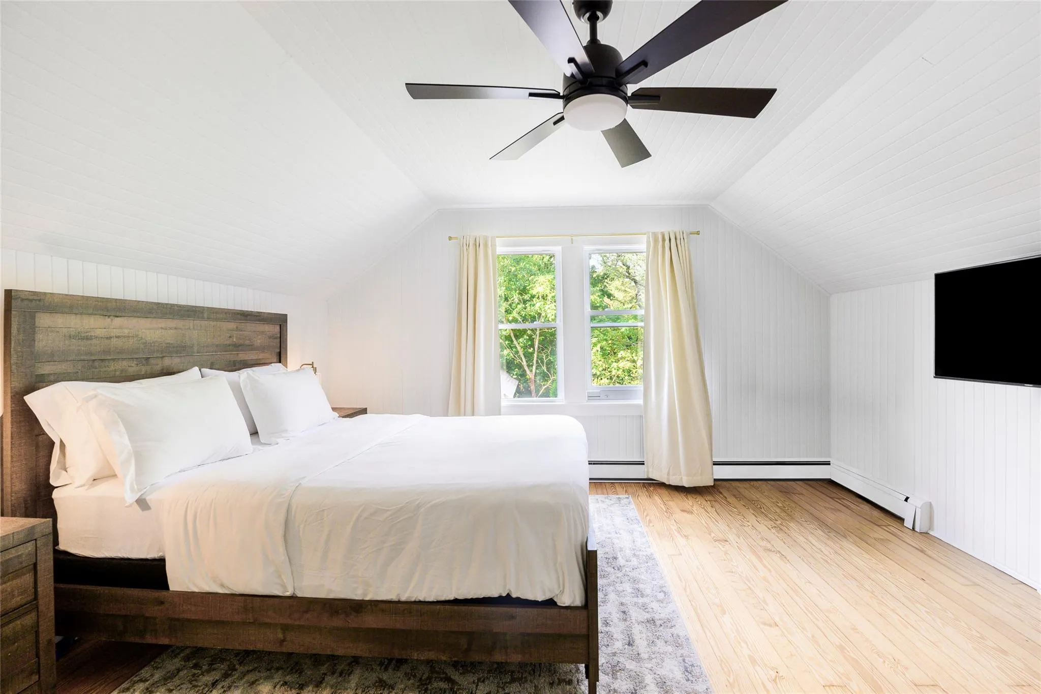 Bedroom ceiling, wood-type flooring, baseboard heating, and ceiling fan Bedroom ceiling, wood-type flooring, baseboard heating, and ceiling fan