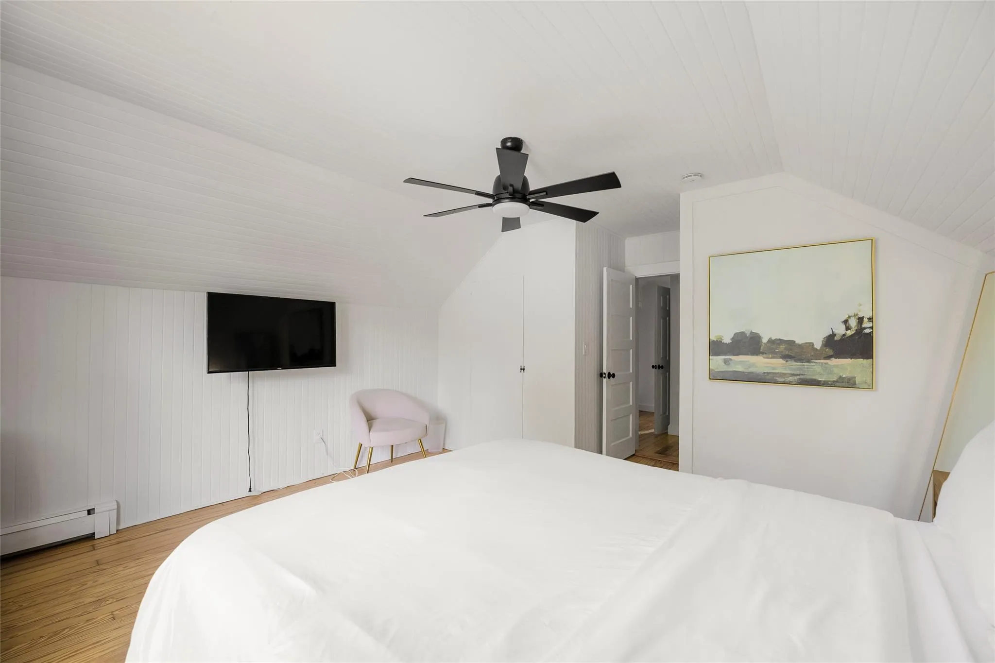 Bedroom with a baseboard heating unit, vaulted ceiling, ceiling fan, and wood finished floors Bedroom with a baseboard heating unit, vaulted ceiling, ceiling fan, and wood finished floors