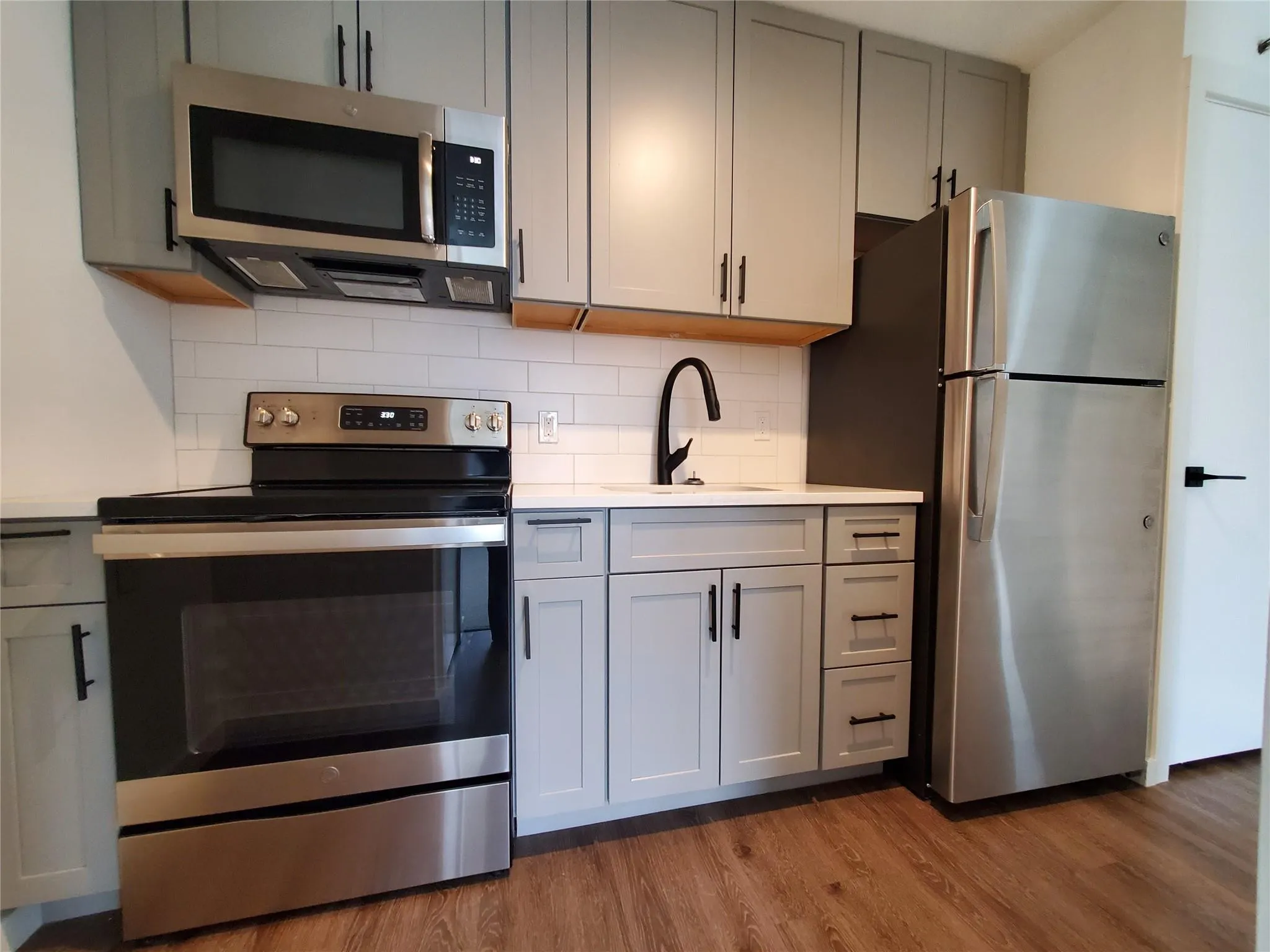 Kitchen with gray cabinetry, a sink, stainless steel appliances Kitchen with gray cabinetry, a sink, stainless steel appliances