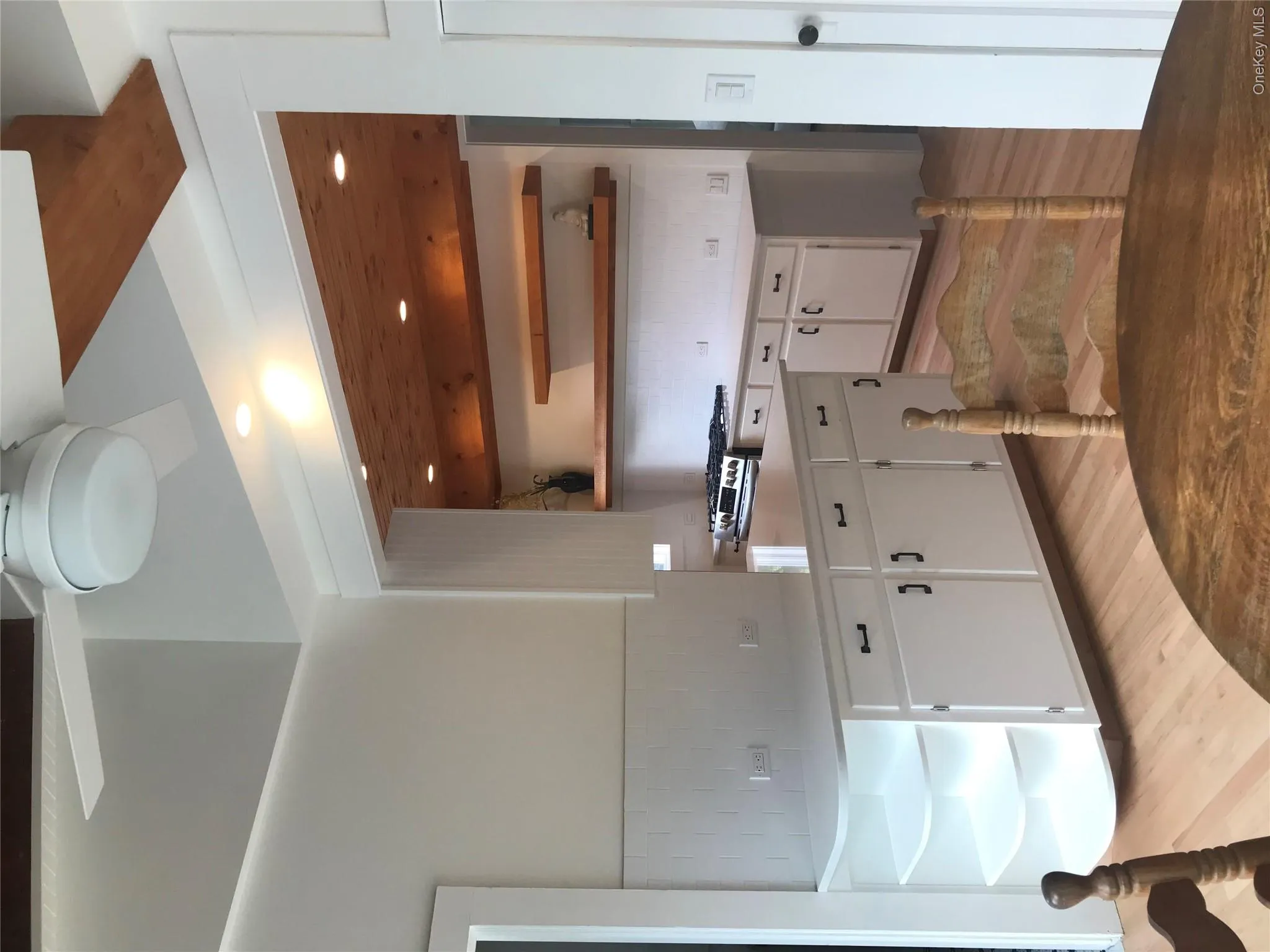 Kitchen featuring white cabinets, backsplash, light wood finished floors, and open shelves Kitchen featuring white cabinets, backsplash, light wood finished floors, and open shelves