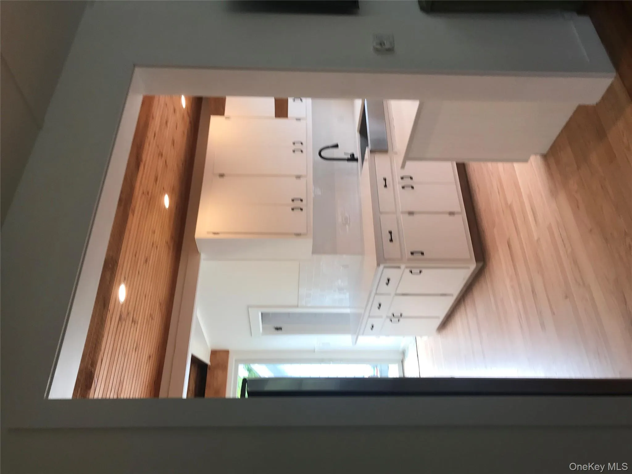 Kitchen featuring light wood finished floors, white cabinets, wooden ceiling, light countertops, and a sink Kitchen featuring light wood finished floors, white cabinets, wooden ceiling, light countertops, and a sink