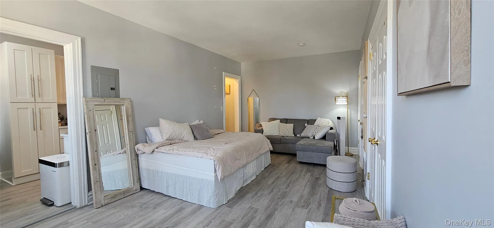 Bedroom featuring electric panel and light wood-style flooring Bedroom featuring electric panel and light wood-style flooring