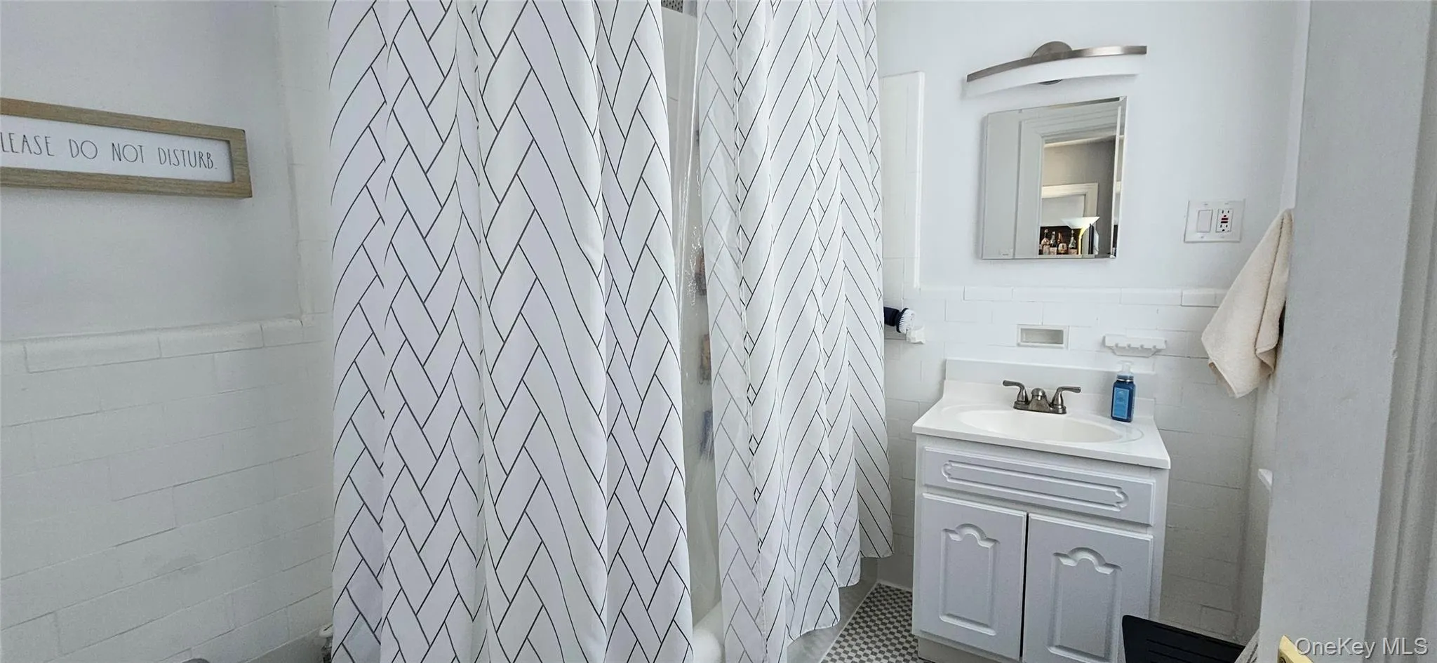 Full bath featuring wainscoting, tile walls, and vanity Full bath featuring wainscoting, tile walls, and vanity