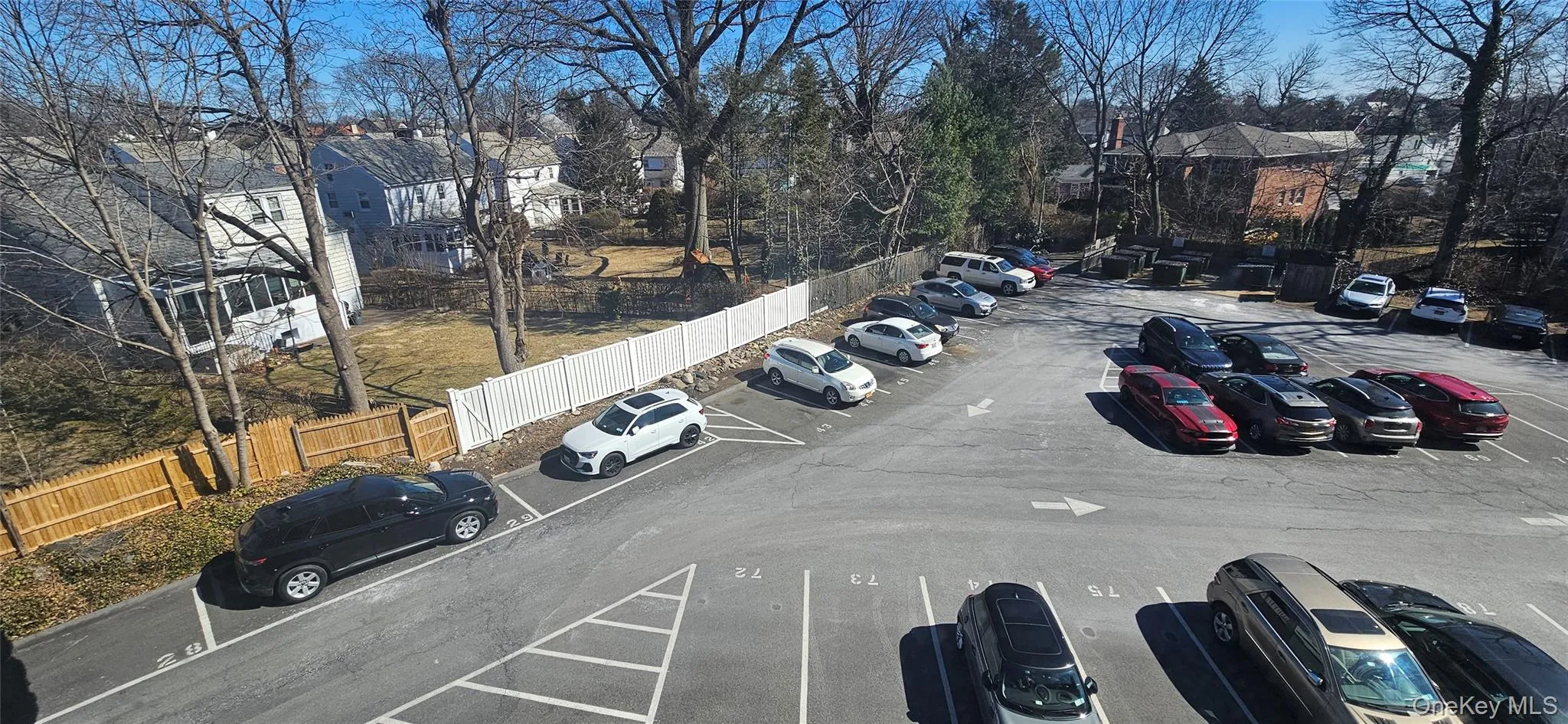 Uncovered parking lot featuring fence Uncovered parking lot featuring fence