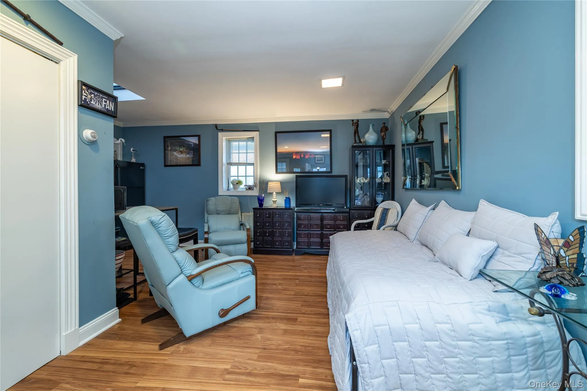 Bedroom with crown molding and wood finished floors Bedroom with crown molding and wood finished floors