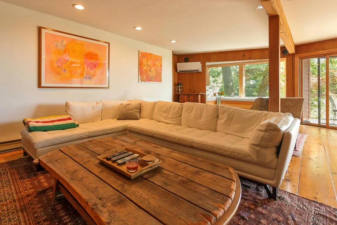 Lower level living area with wooden walls, hardwood / wood-style flooring, beamed ceiling, a wall mounted AC, and recessed lighting Lower level living area with wooden walls, hardwood / wood-style flooring, beamed ceiling, a wall mounted AC, and recessed lighting