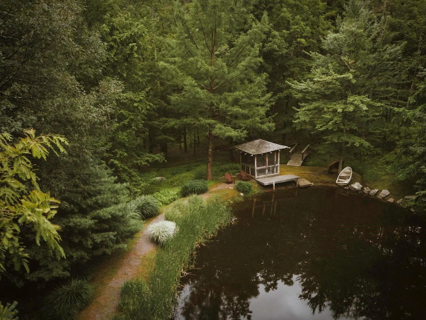 Drone / aerial view featuring a woods and pond Drone / aerial view featuring a woods and pond