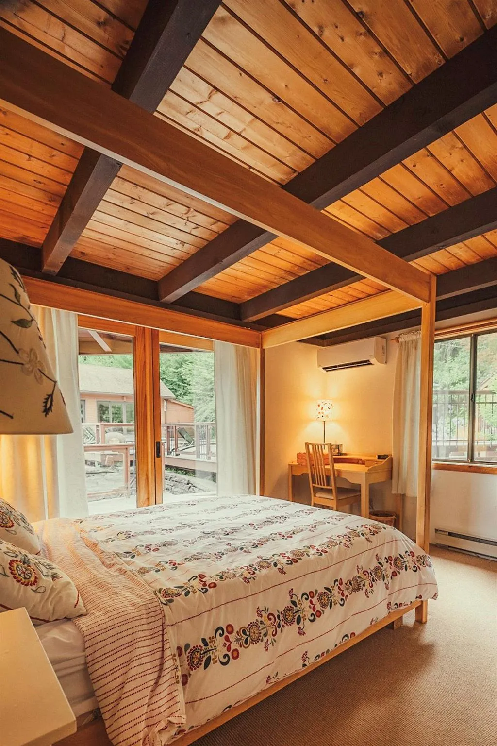 Bedroom featuring beam ceiling, carpet flooring, access to outside, wooden ceiling, and a wall mounted air conditioner Bedroom featuring beam ceiling, carpet flooring, access to outside, wooden ceiling, and a wall mounted air conditioner