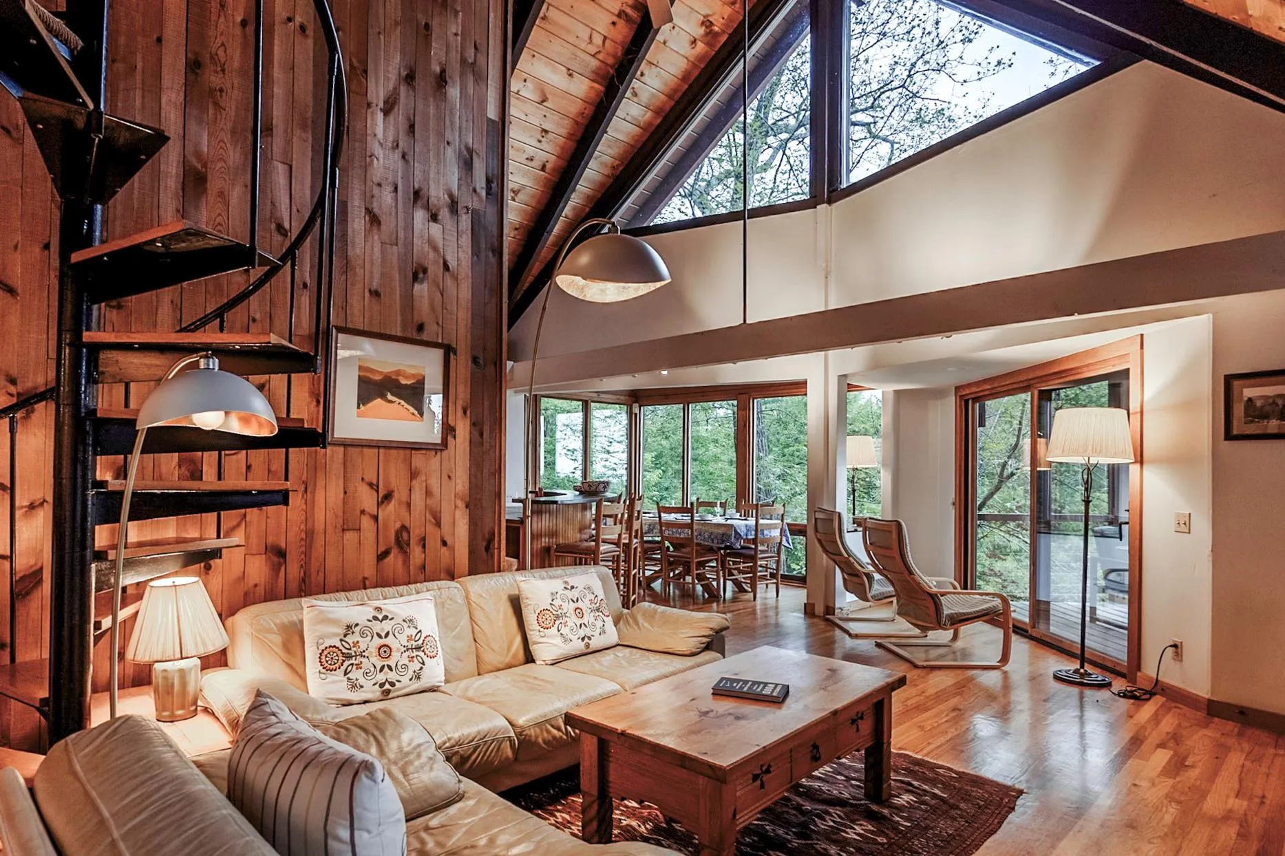 Living room featuring a wealth of natural light, high vaulted ceiling, wood finished floors, and beamed ceiling Living room featuring a wealth of natural light, high vaulted ceiling, wood finished floors, and beamed ceiling