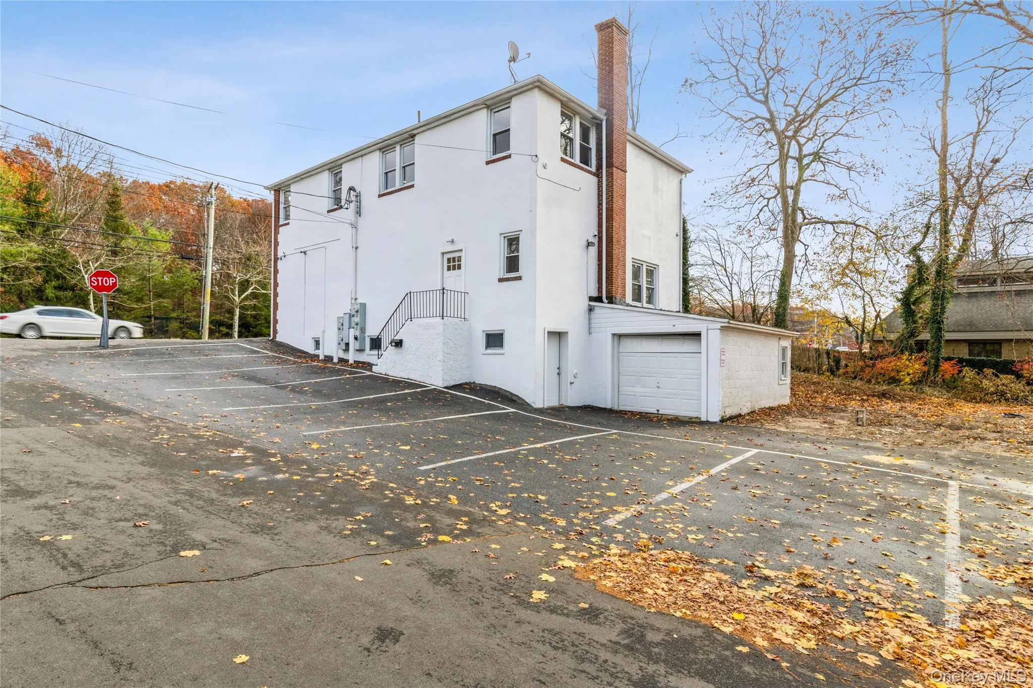 View of side of property with uncovered parking and stucco siding View of side of property with uncovered parking and stucco siding