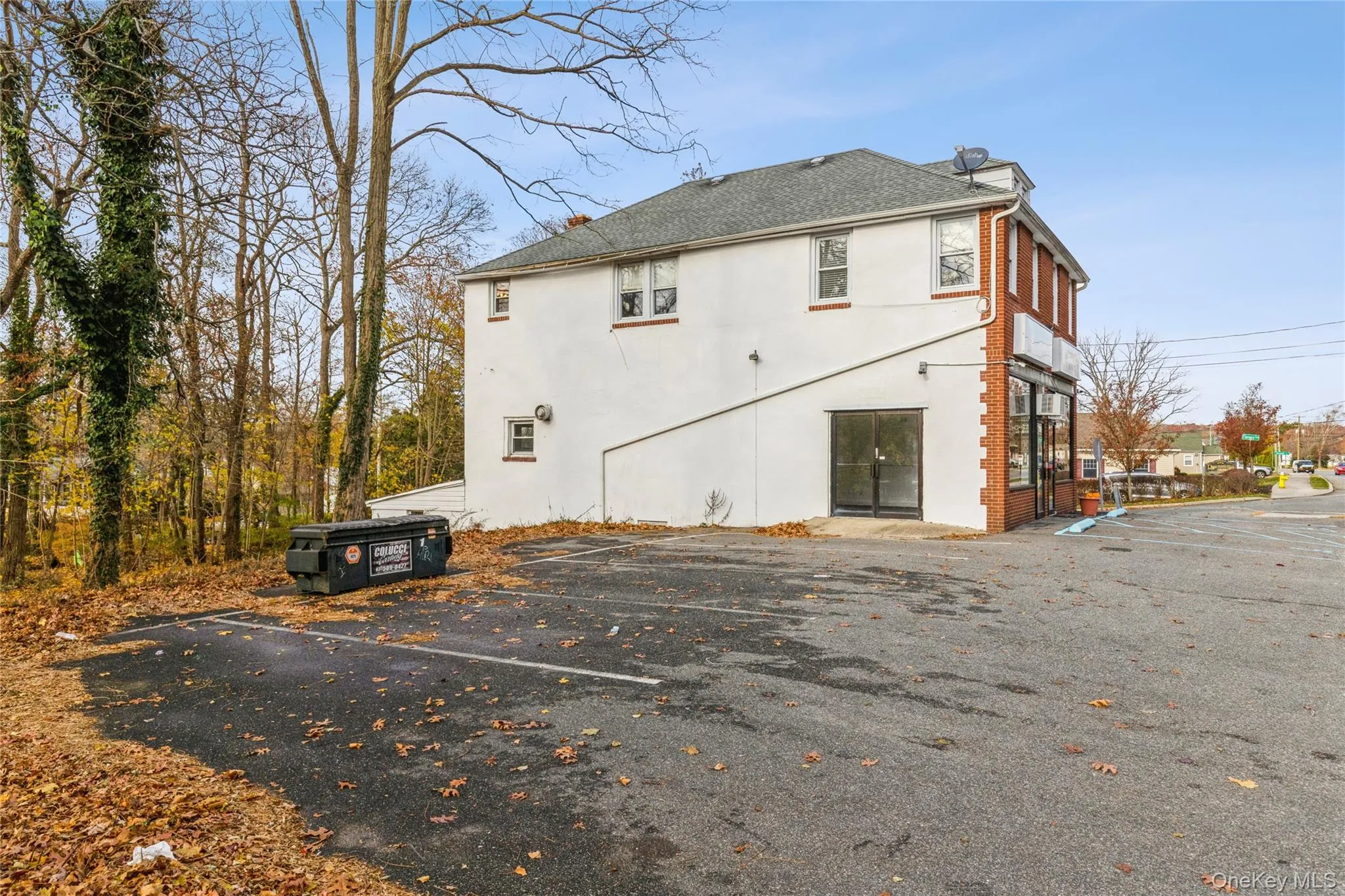 Rear view of house featuring uncovered parking, roof with shingles, and stucco siding Rear view of house featuring uncovered parking, roof with shingles, and stucco siding