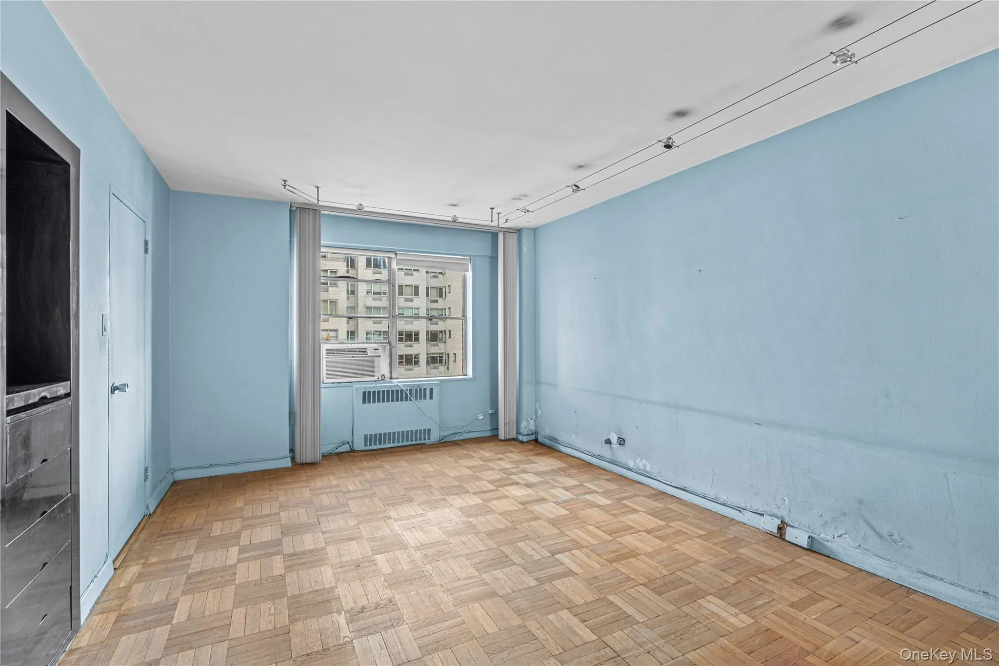 Empty room featuring cooling unit and radiator heating unit Empty room featuring cooling unit and radiator heating unit