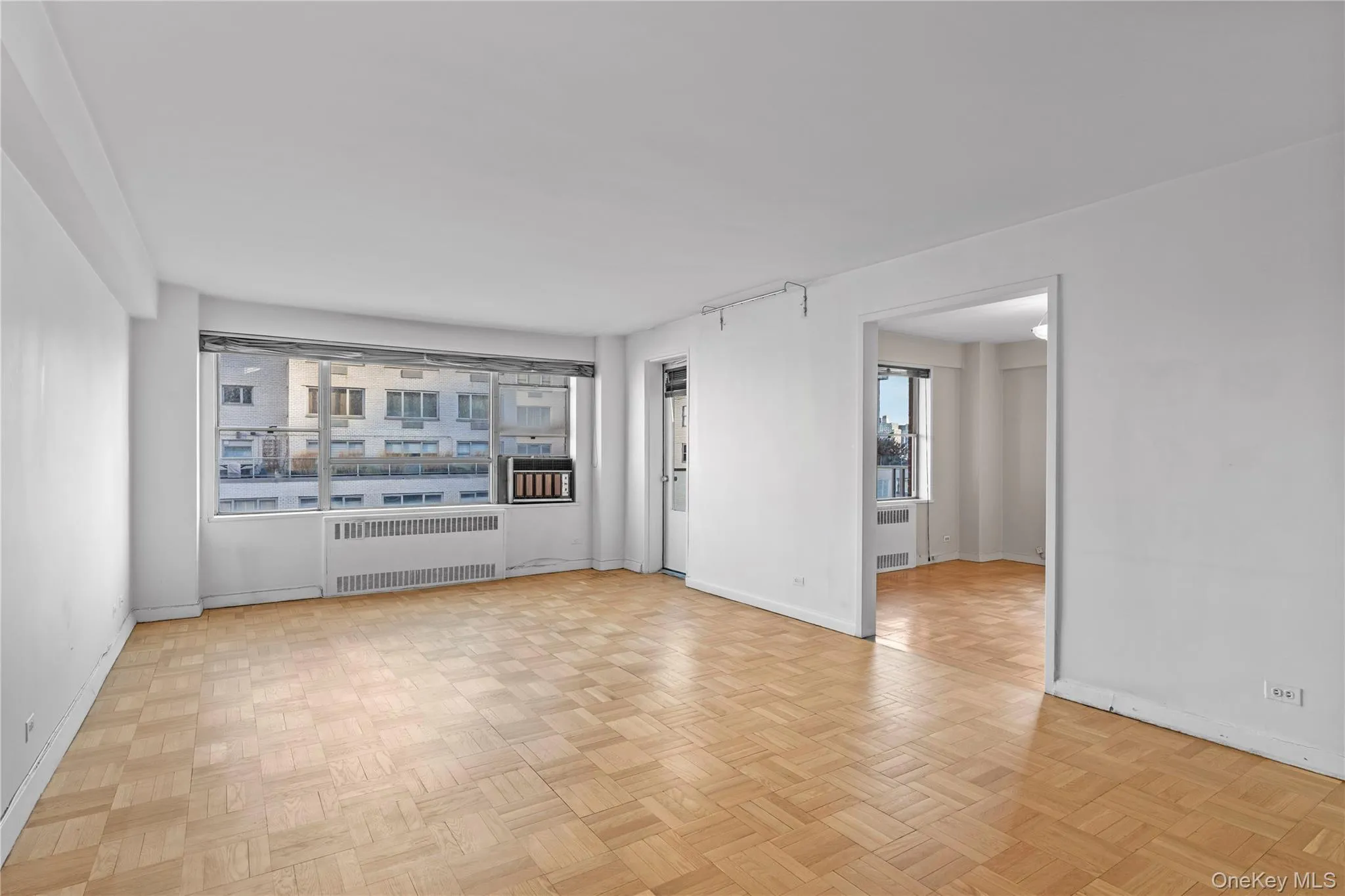 Unfurnished living room featuring baseboards and radiator Unfurnished living room featuring baseboards and radiator