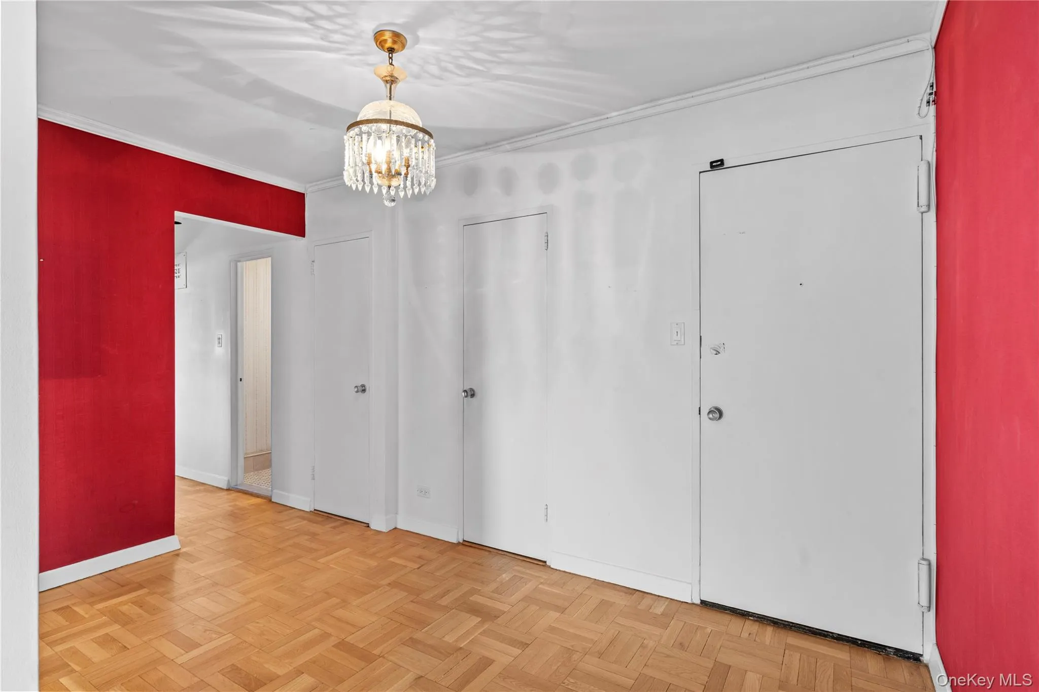 Unfurnished bedroom featuring crown molding, a notable chandelier, and baseboards Unfurnished bedroom featuring crown molding, a notable chandelier, and baseboards