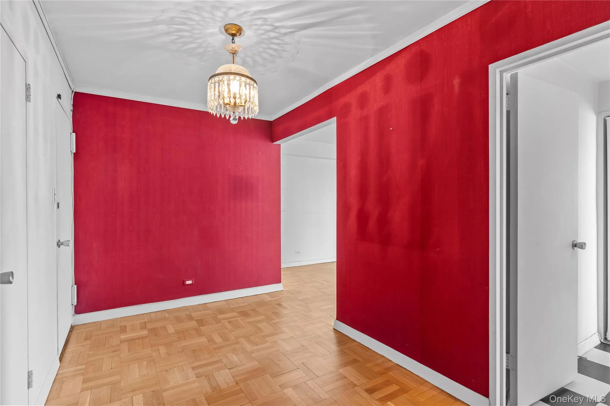 Unfurnished room featuring an inviting chandelier, baseboards, and ornamental molding Unfurnished room featuring an inviting chandelier, baseboards, and ornamental molding